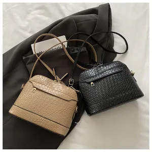 Detail of woven texture shell bags in khaki and black with gold hardware and zippers