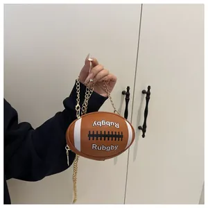 Close-up of a rugby-shaped crossbody bag featuring white lettering and a gold chain strap