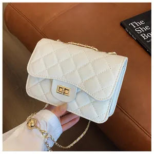 Close-up of white quilted leather bag with golden twist-lock and chain strap detail