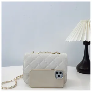 Detailed quilted texture of white crossbody bag with gold chain and phone size reference