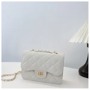 Close-up of white quilted chain bag with gold rotary lock and leather strap detail