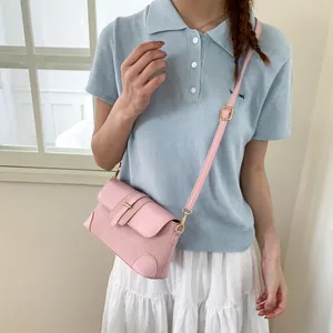 Détail du sac bandoulière rose tressé avec boucle dorée et rabat en cuir lisse élégant