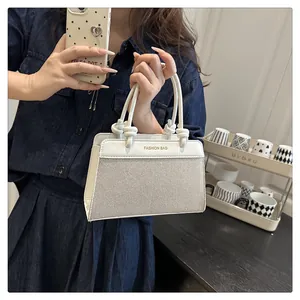 Detail of cream contrast stitching handbag with woven texture and knotted top handle