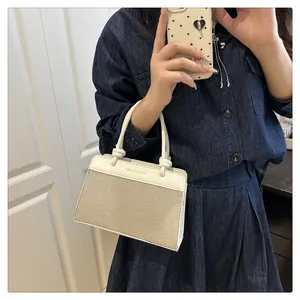 Detail of white leather and beige canvas handbag with cylindrical knot handle