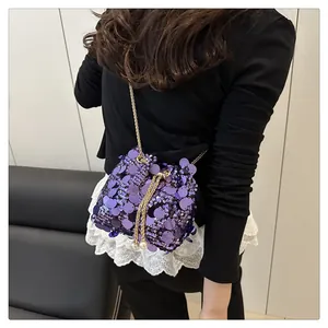 Dettaglio borsa a secchiello viola con paillettes, catena dorata e ciondoli di perle