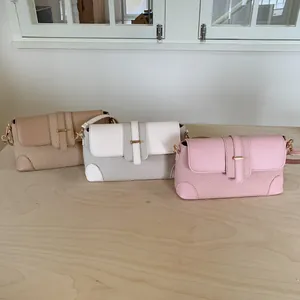 Détails de trois sacs bandoulière en kaki, beige et rose avec texture tressée