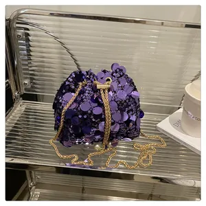 Dettaglio ravvicinato delle paillettes viola e della catena dorata sulla borsa