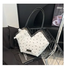 Detail of quilted bucket bag with bow print and lace pearl pendant in a metal basket