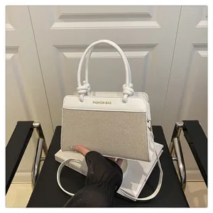 Detail of canvas and leather contrast handbag with elegant knot handle and shoulder strap