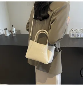 Gesteppte beige Trapez-Eimertasche in einer stilvollen, minimalistischen Café-Szene
