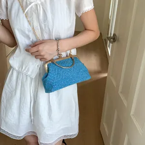 Close-up of sky blue tweed fabric texture on a retro metal frame crossbody handbag