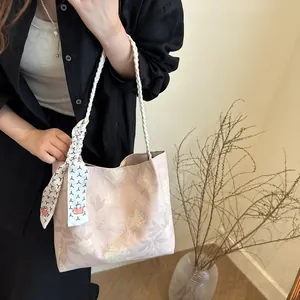 Sac fourre-tout floral avec poignées tressées et foulard montré sous une vue latérale