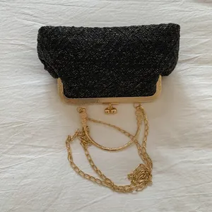 Detail of black tweed evening bag with gold shimmering threads and metallic clasp