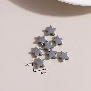 Macro detail of 1cm silver star charms with side holes for DIY jewelry making