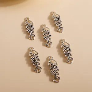 Detailed macro view of six vintage silver fish bone charms with hollow alloy texture