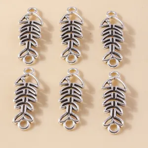 Macro view of six vintage silver alloy hollow fishbone charms for DIY jewelry making