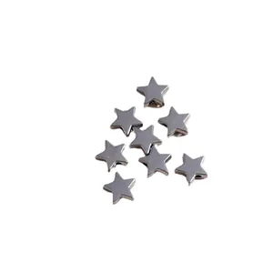 Macro view of silver-tone alloy star pendants showing side holes for DIY jewelry
