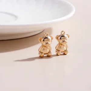 Detail of golden bear charm with matte finish and bow accent for DIY jewelry making