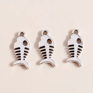 Detailed macro view of three vintage silver fishbone charms with hollow bone structure