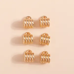 Detailed view of 6 gold plated textured barrel connector charms for DIY jewelry making