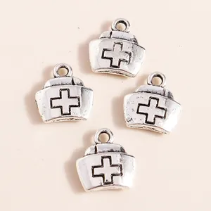 Vue détaillée de pendentifs chapeau d'infirmière vintage argentés avec relief de croix