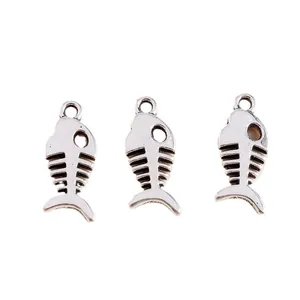 Three vintage silver fish bone charms for DIY jewelry making on white background