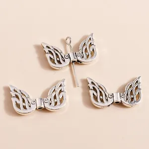 Macro view of vintage silver hollow wing charms for DIY jewelry making accessories