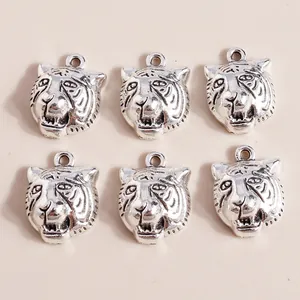 Detailed view of six vintage silver tiger head alloy charms for jewelry DIY crafting