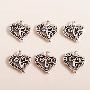 Detail of vintage heart-shaped hollow charms in antique silver finish for DIY jewelry