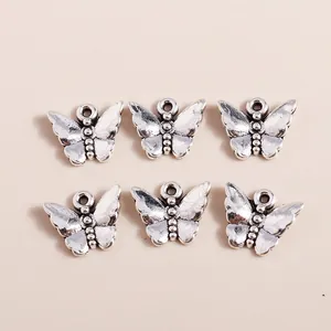 Macro detail of vintage silver butterfly charms showing metal texture and DIY hanging loops