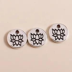 Macro view of vintage silver alloy round pendants with engraved lotus flower design