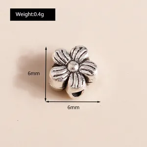 Macro detail of a 6mm antique silver flower bead showing size and 0.4g weight specs