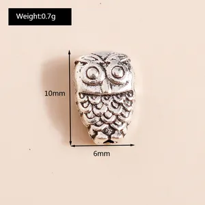 Macro detail of antique silver owl charm with intricate feather texture and 10mm height