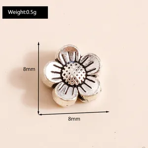 Macro detail of 8mm vintage silver alloy flower charm showing weight and dimensions