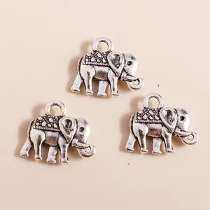 Close-up of three vintage silver elephant pendants with detailed embossed textures