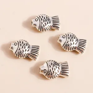 Detail of vintage silver fish charms for DIY jewelry with textured scales and fins