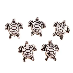 Macro detail of antique silver turtle charms with textured shells for DIY jewelry making