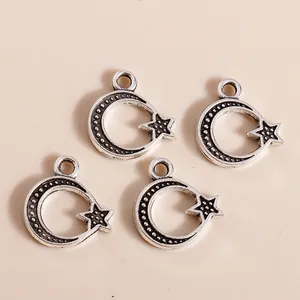 Antique silver moon and star alloy charms for DIY jewelry making on beige surface
