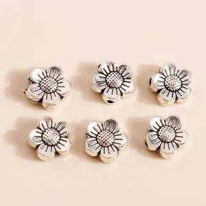 Detailed view of six vintage silver flower beads with intricate petal textures and holes