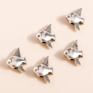 Antique silver fish alloy pendants for DIY jewelry making five pieces set shown on beige background