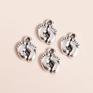 Macro shot of retro silver metal baby footprint charms with detailed toe contours for DIY