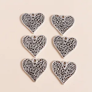 Detailed close-up of vintage silver alloy hollow heart charms with textured patterns