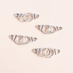 Close-up of silver handcuff charms with Freedom engraving for DIY jewelry making