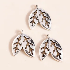 Macro detail of three vintage silver-plated leaf pendants for DIY jewelry making