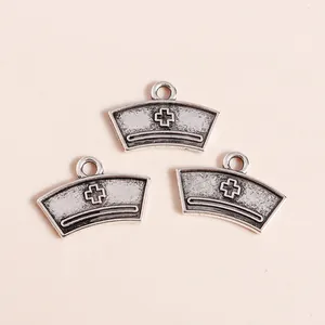 Detailed view of vintage silver nurse cap pendants with cross icons for DIY jewelry