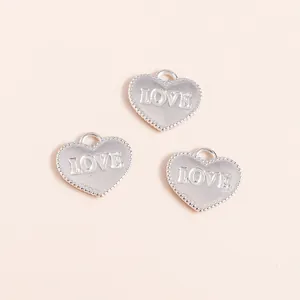 Detailed view of silver heart charms with LOVE engraving and beaded edge for DIY jewelry