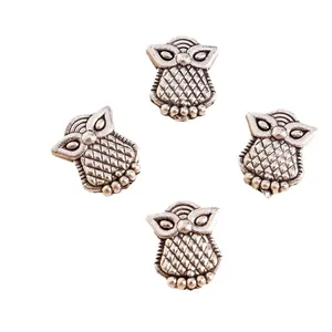 Detail view of four antique silver owl pendants with intricate carved feather textures