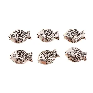 Detailed view of six vintage silver fish pendants showing intricate scales and textures