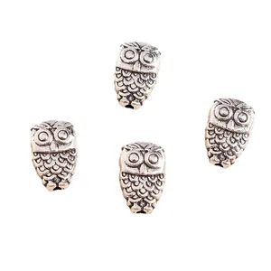 Detailed macro view of four antique silver owl pendants with intricate feather texture