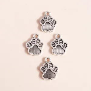 Macro detail of silver alloy paw print pendants with textured stripes and top rings
